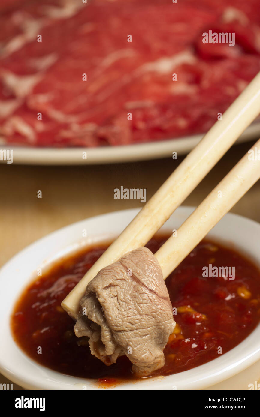 Mongolian Hot Pot, dipping cooked lamb in chili sauce Stock Photo Alamy