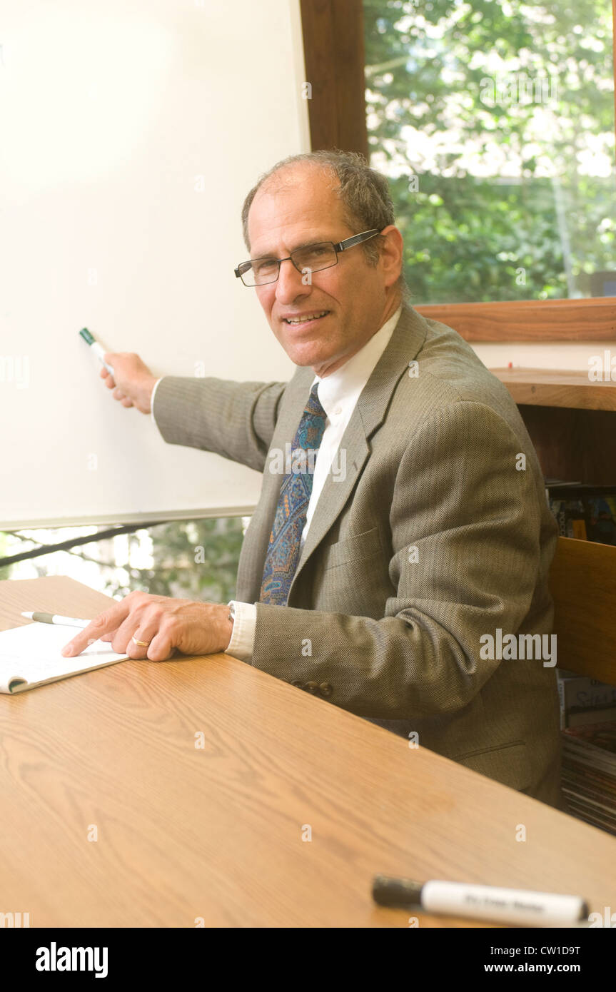 senior business executive in conference office giving presentation with blank white display board Stock Photo