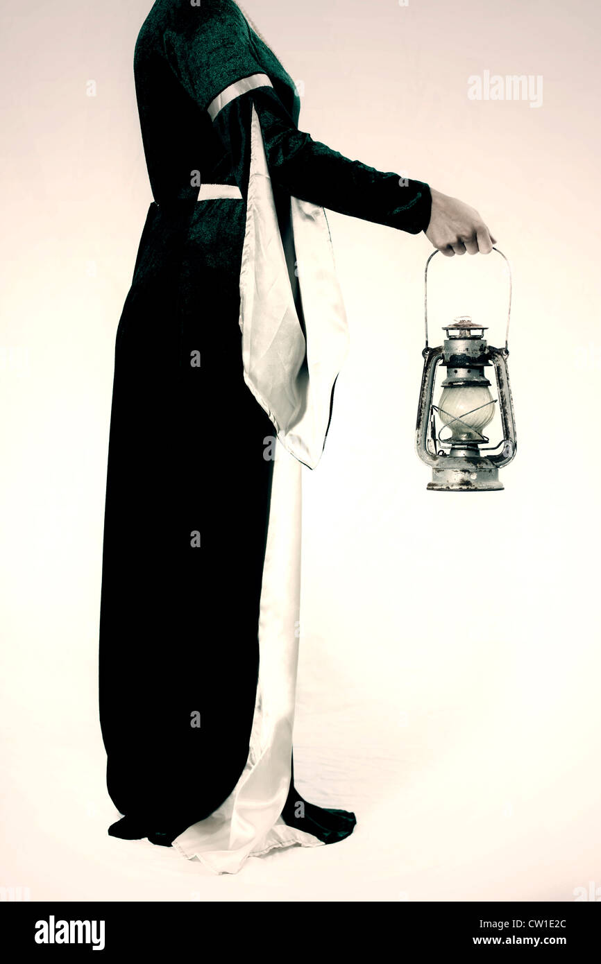 a woman in a Victorian dress with an old lantern Stock Photo - Alamy