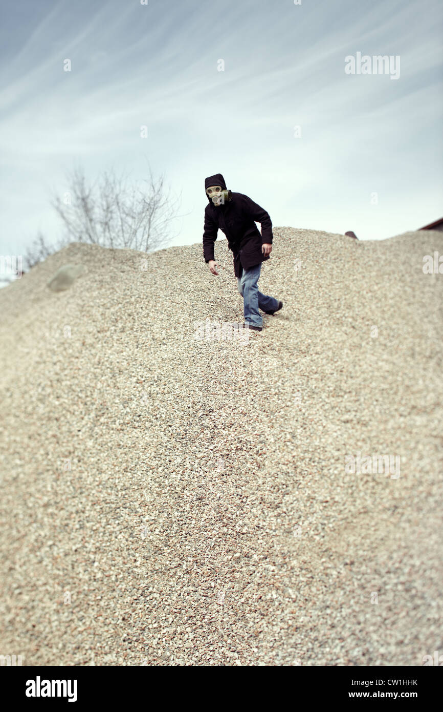 Human in gas mask running in the desert after doomsday Stock Photo