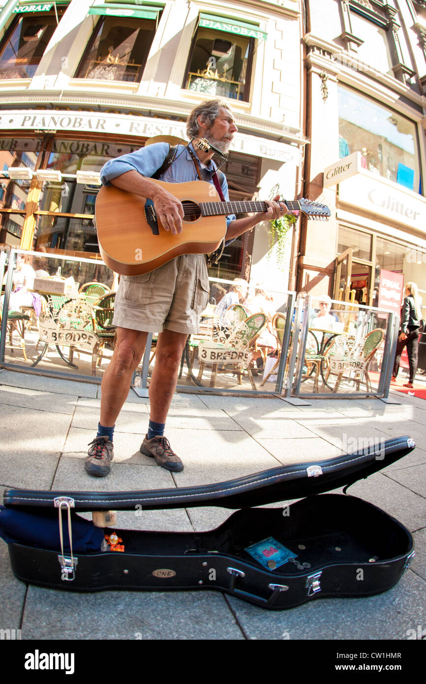 A man playing a guitar and a harmonica in the main street, Karl Johan, in  Oslo, Norway Stock Photo - Alamy