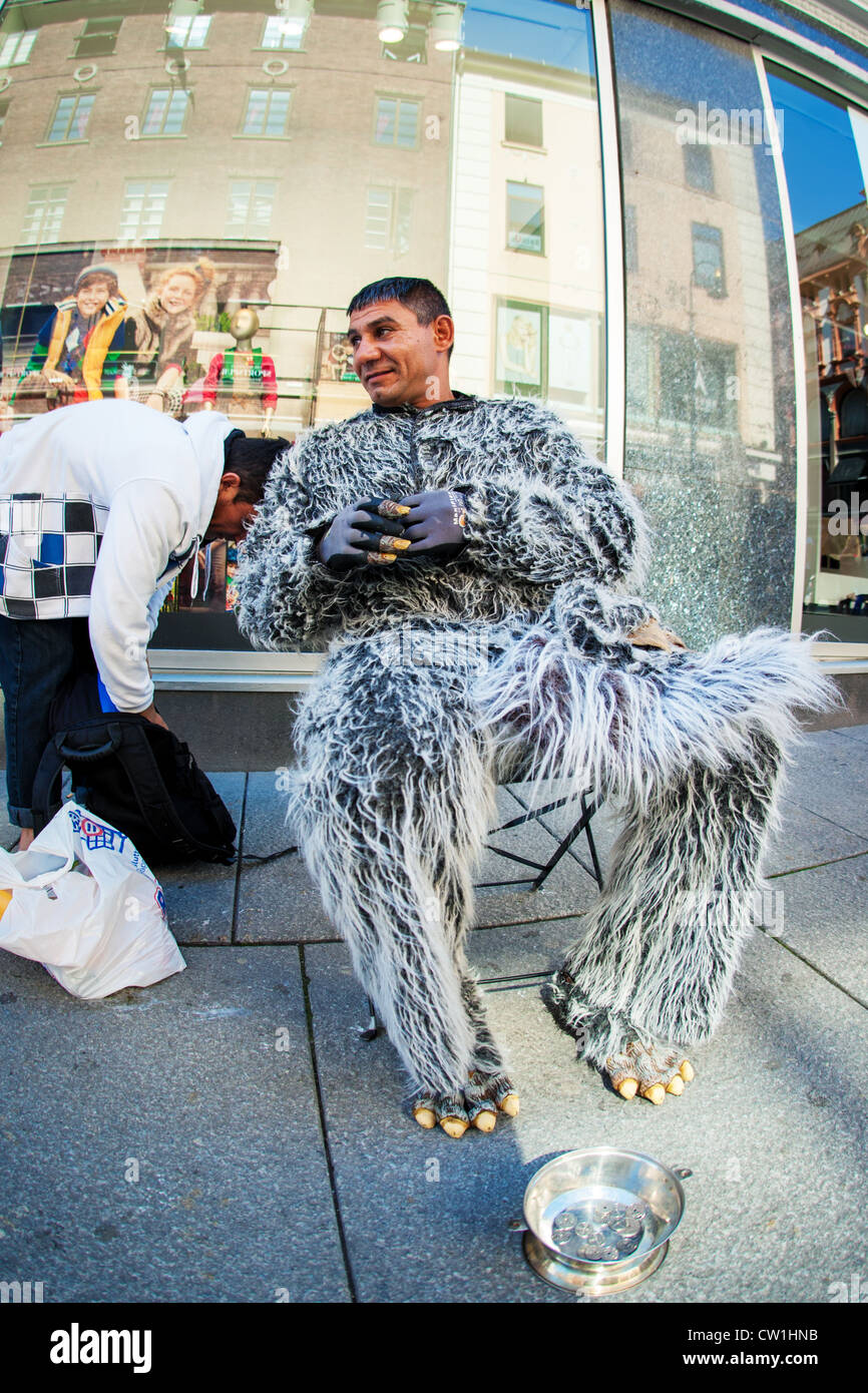 A man dressed in a wolf costume sitting on a bench on the Main Street