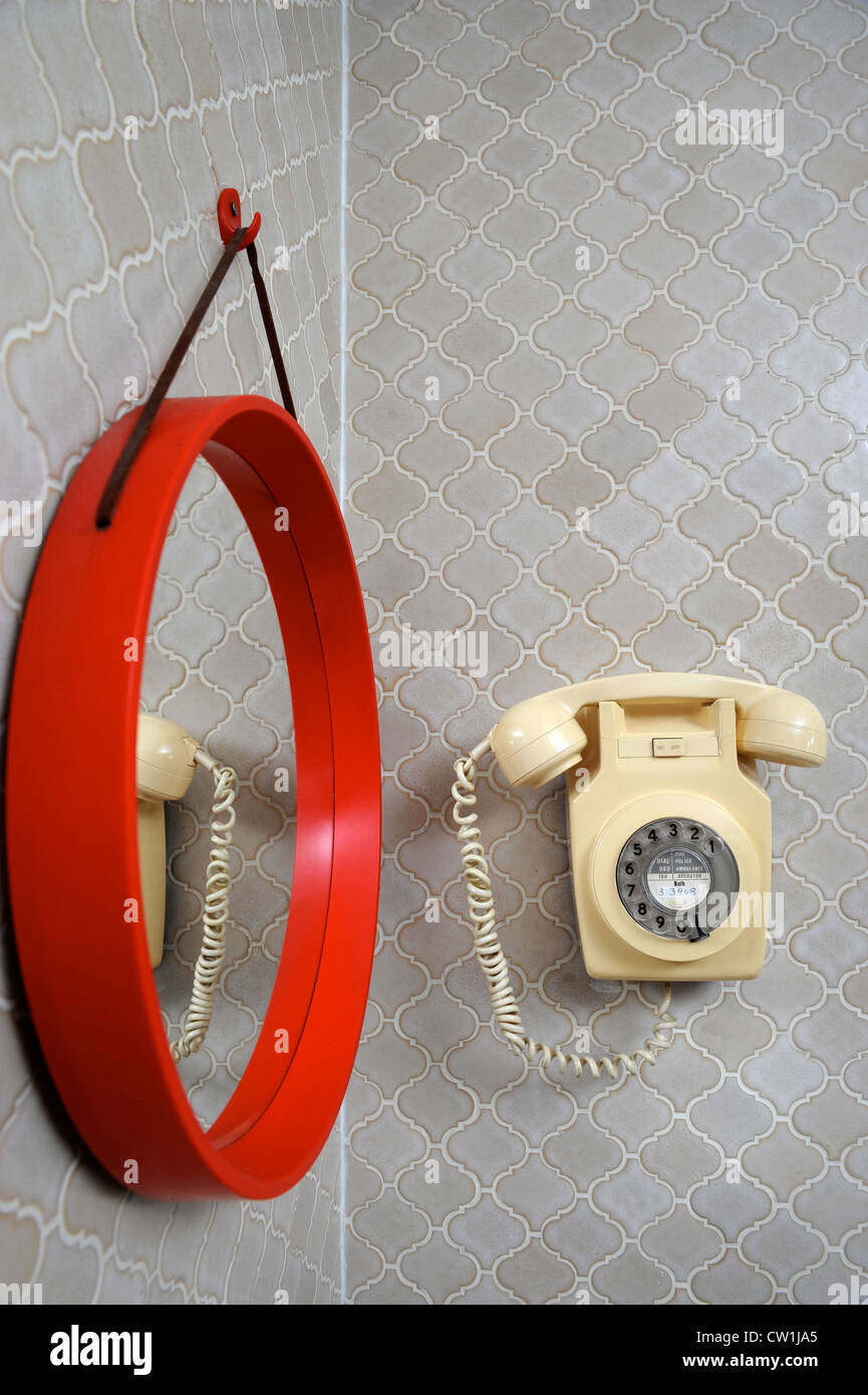 A classic wall mounted bakelite telephone in a 1970's style house which was featured in a 1975 magazine makeover UK Stock Photo