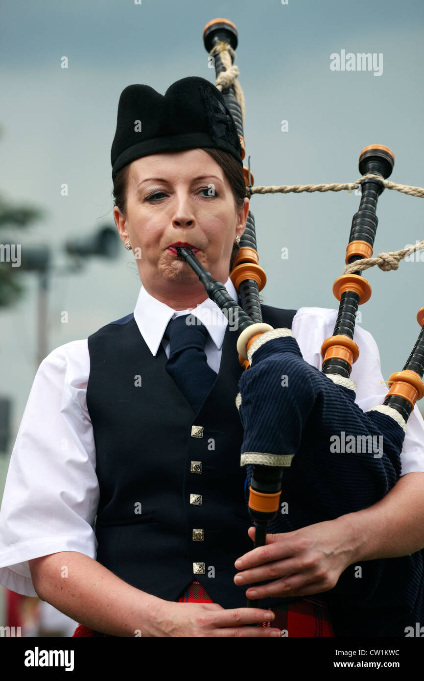 Woman playing the bagpipes at a piping competition, Dundonald Highland Games, Ayrshire,Scotland, UK, Great Britain Stock Photo