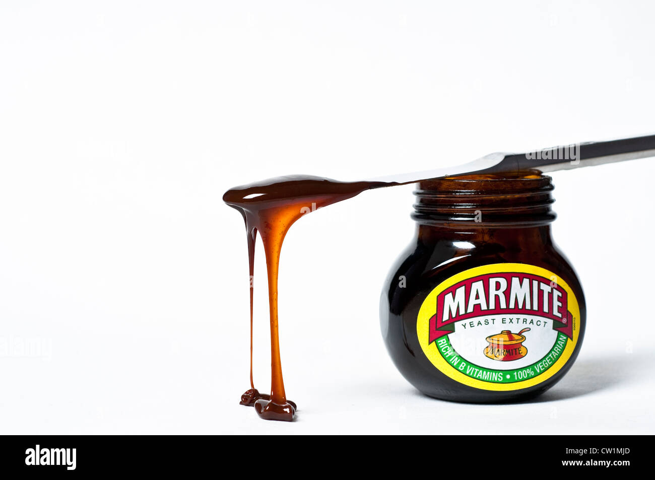 Knife with dripping marmite on top of a jar Marmite Stock Photo