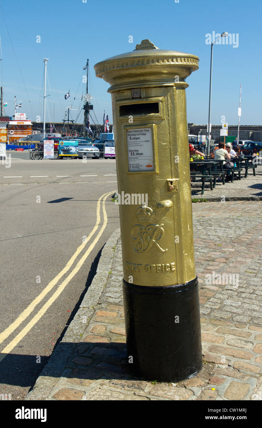 Royal Mail post box painted gold in honour of Helen Glover, 2012 London Olympics gold medal winner.  Penzance UK. Stock Photo