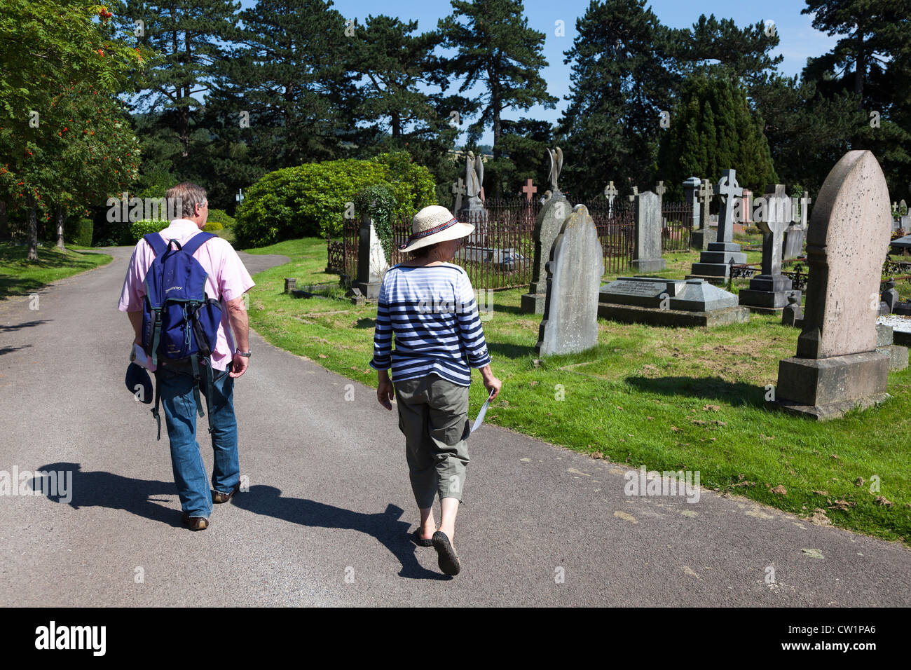 Two people walking through cemetery, Wales, UK Stock Photo