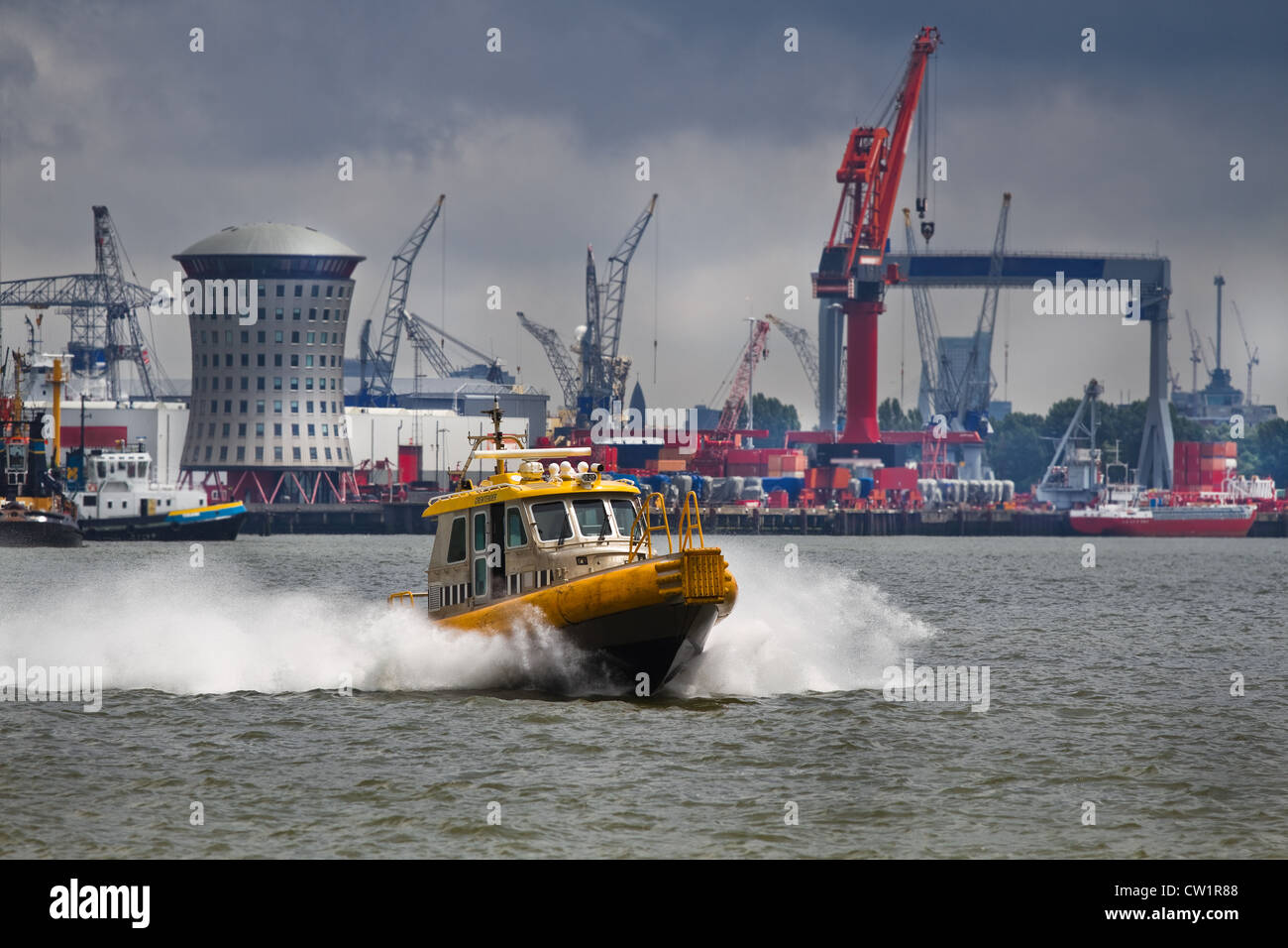 Crewtender on the river with industrial background and upcoming rainstorm Stock Photo