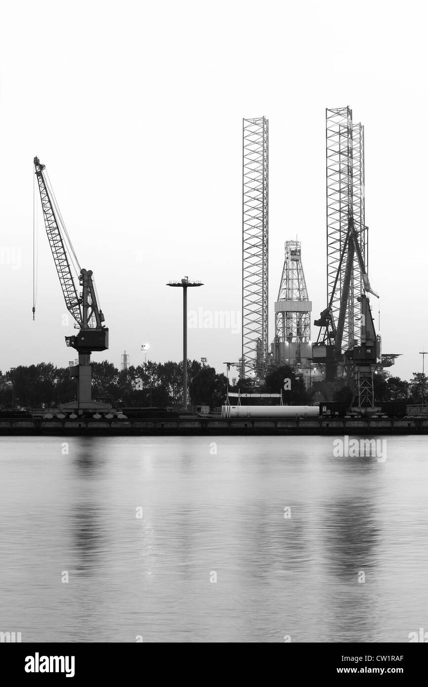 Construction- and ship-repair industry, cranes and drilling rig - vertical black and white image Stock Photo
