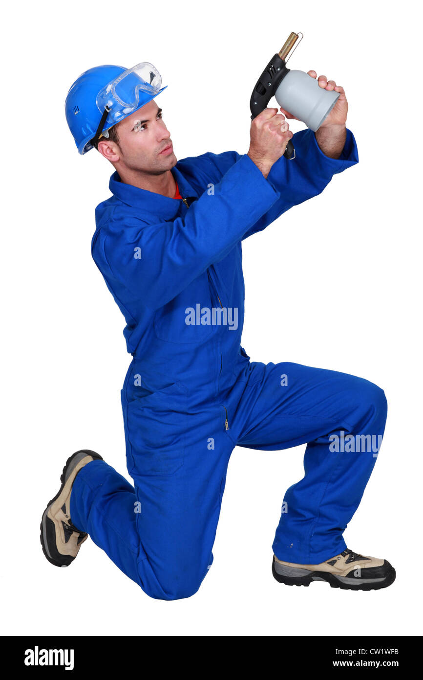 Man Using Blowtorch Man kneeling whist using blow torch Stock Photo - Alamy