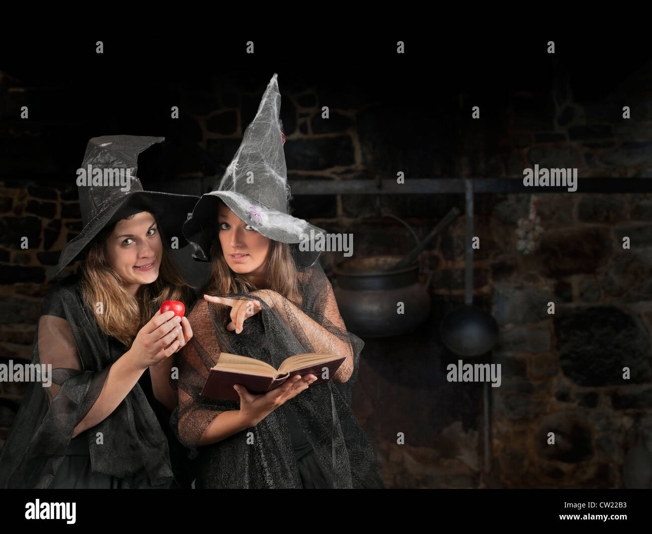 two halloween witches with apple and book Stock Photo