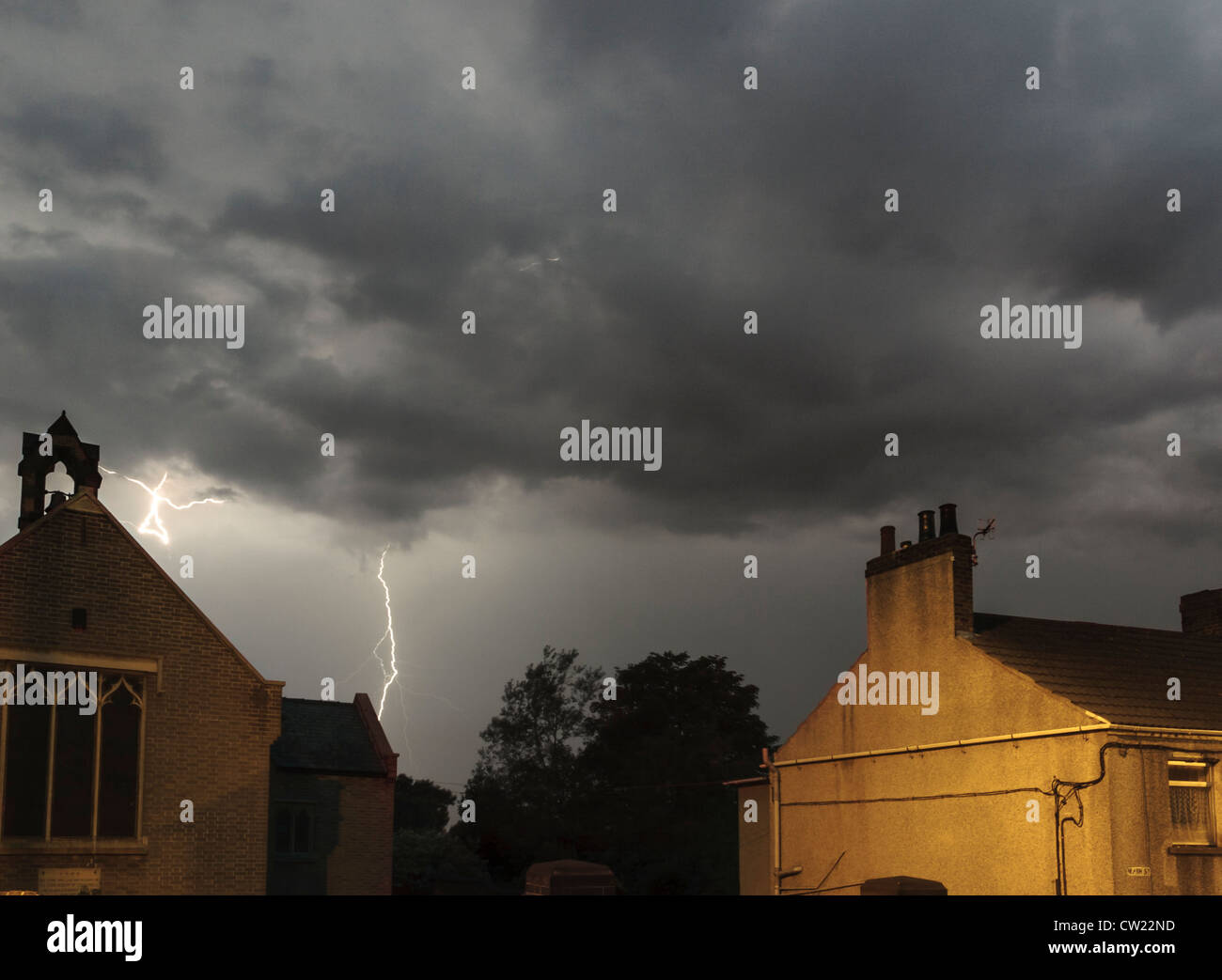 Lightning bolt strike in a night time stormy sky behind the Church Of Saint Peter, Awsworth