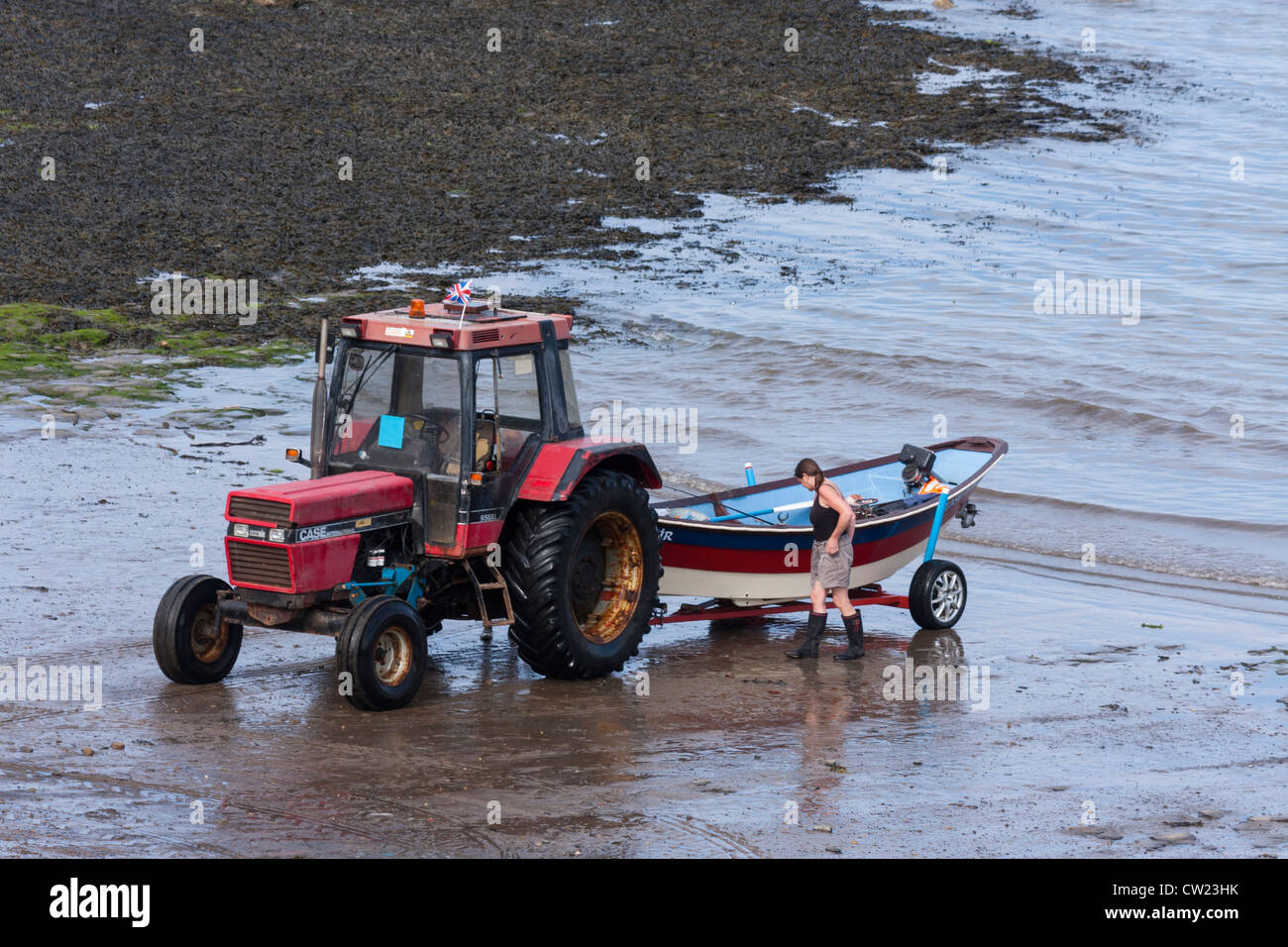 A tractor launching a boat from the beach Stock Photo Alamy