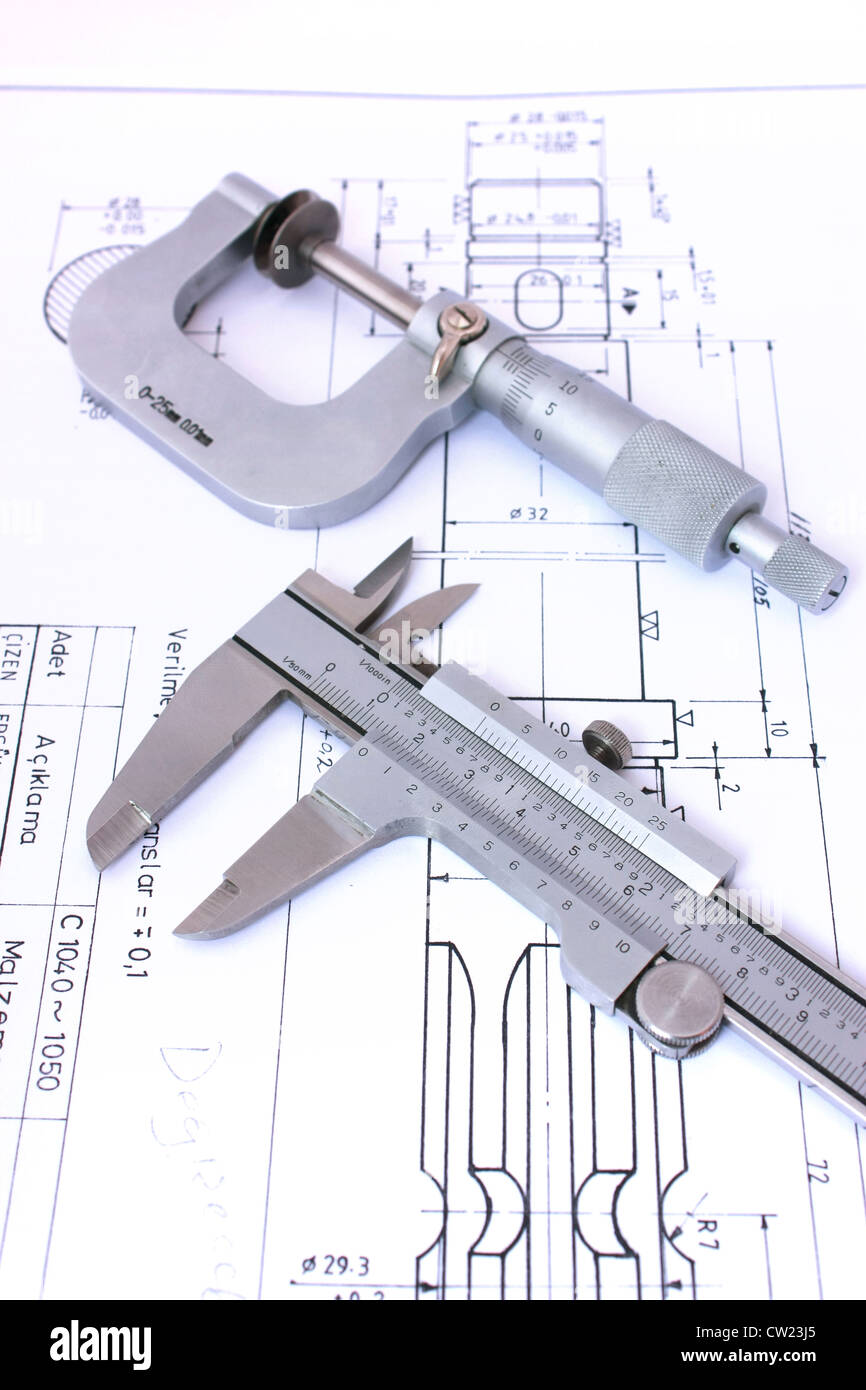 Micrometer and caliper on blueprint vertical. Shallow depth of field