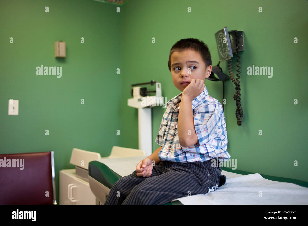 5 year old boy nervously waiting for an examination at the doctors office Stock Photo
