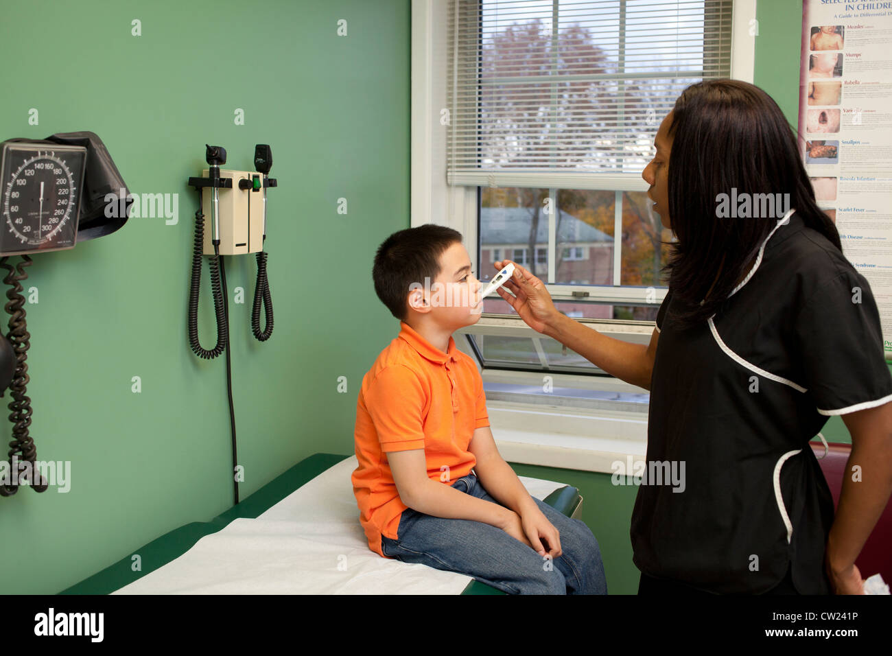 5 year old boy having his temperature taken at the doctors office Stock Photo
