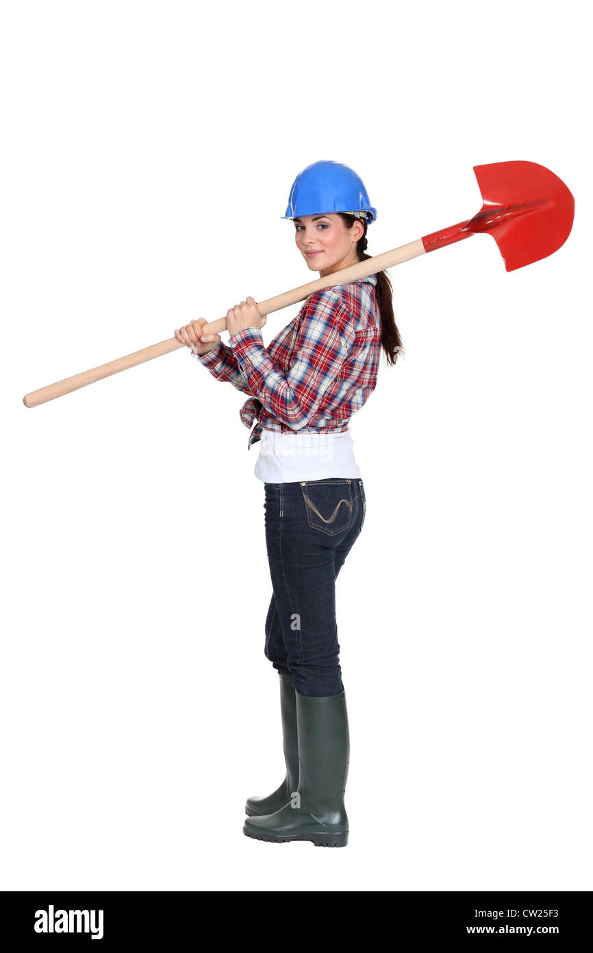 Female manual worker carrying shovel Stock Photo