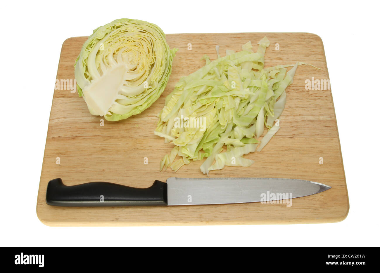 Cut white cabbage with a knife on a wooden chopping board isolated