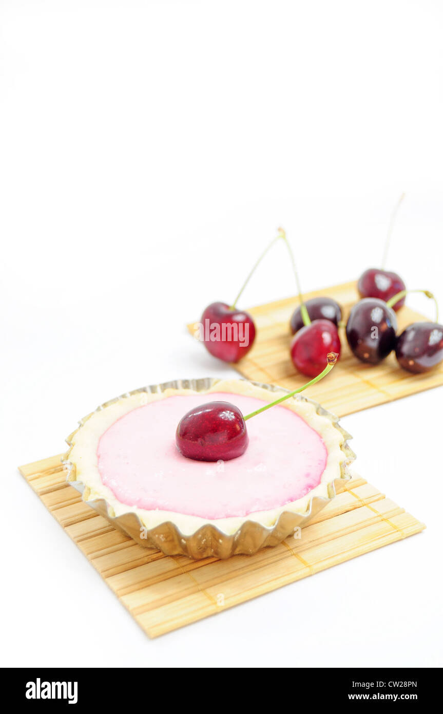 Tart decorated with cherry and cherries in the background Stock Photo