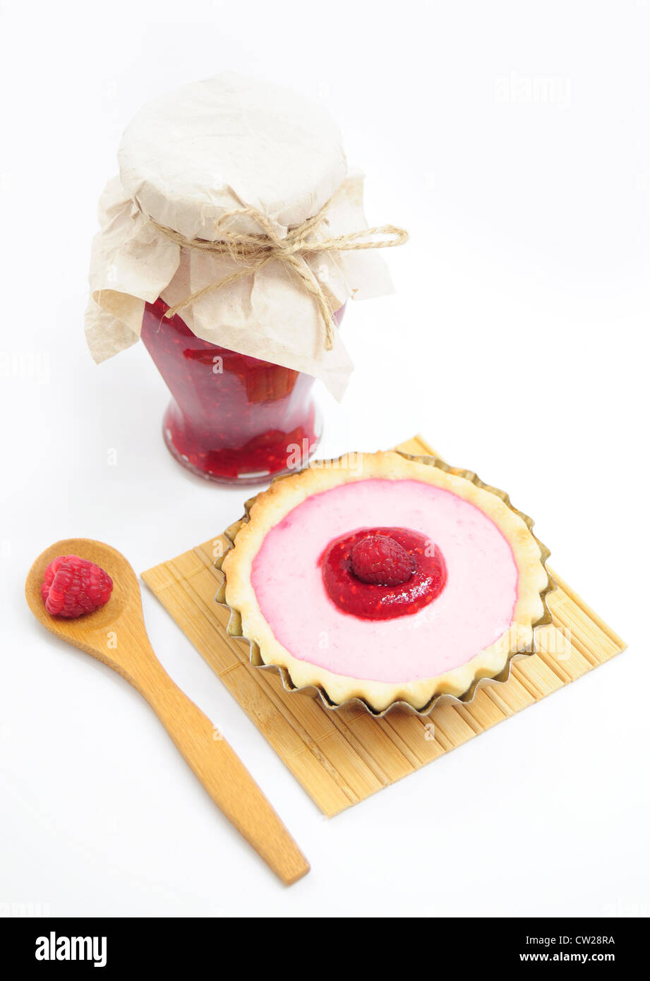 Jar of raspberry jam, tart with cream and wooden spoon with fresh fruit Stock Photo