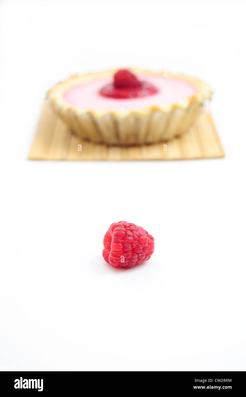 Single raspberry and raspberry tart in the background Stock Photo