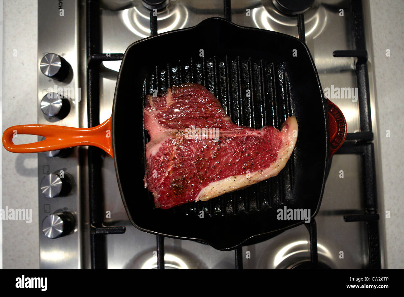 Raw Tbone steak in frying pan getting cooked Stock Photo Alamy