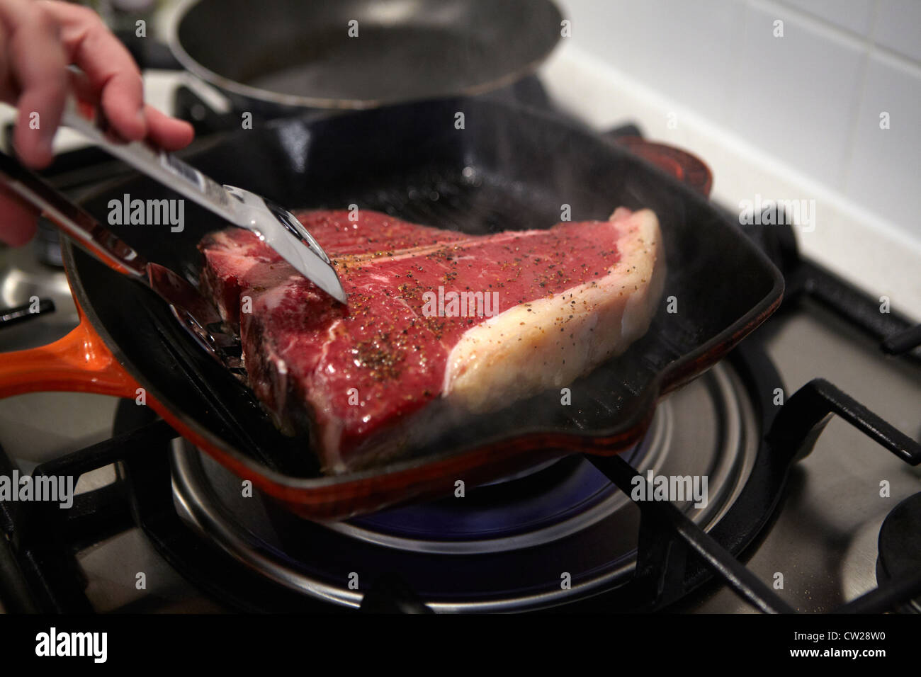 Raw Tbone steak in frying pan getting cooked Stock Photo Alamy