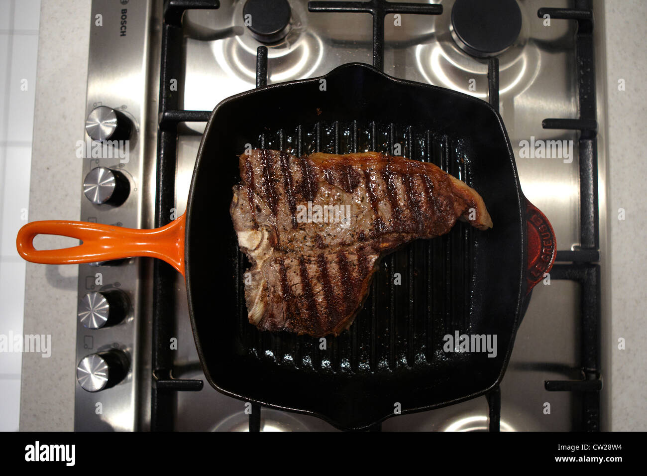 Tbone steak in frying pan getting cooked Stock Photo Alamy