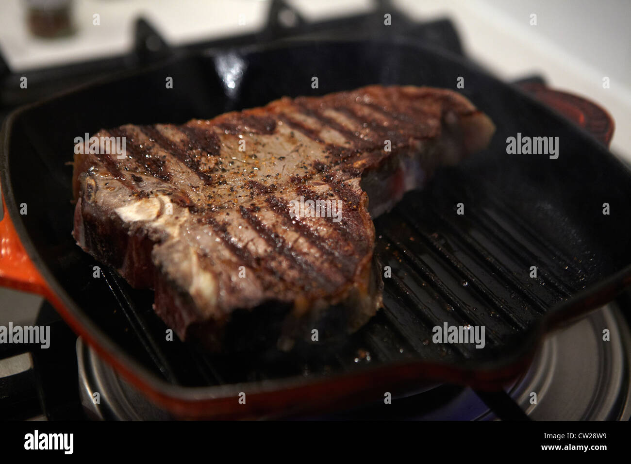 Tbone steak in frying pan getting cooked Stock Photo Alamy