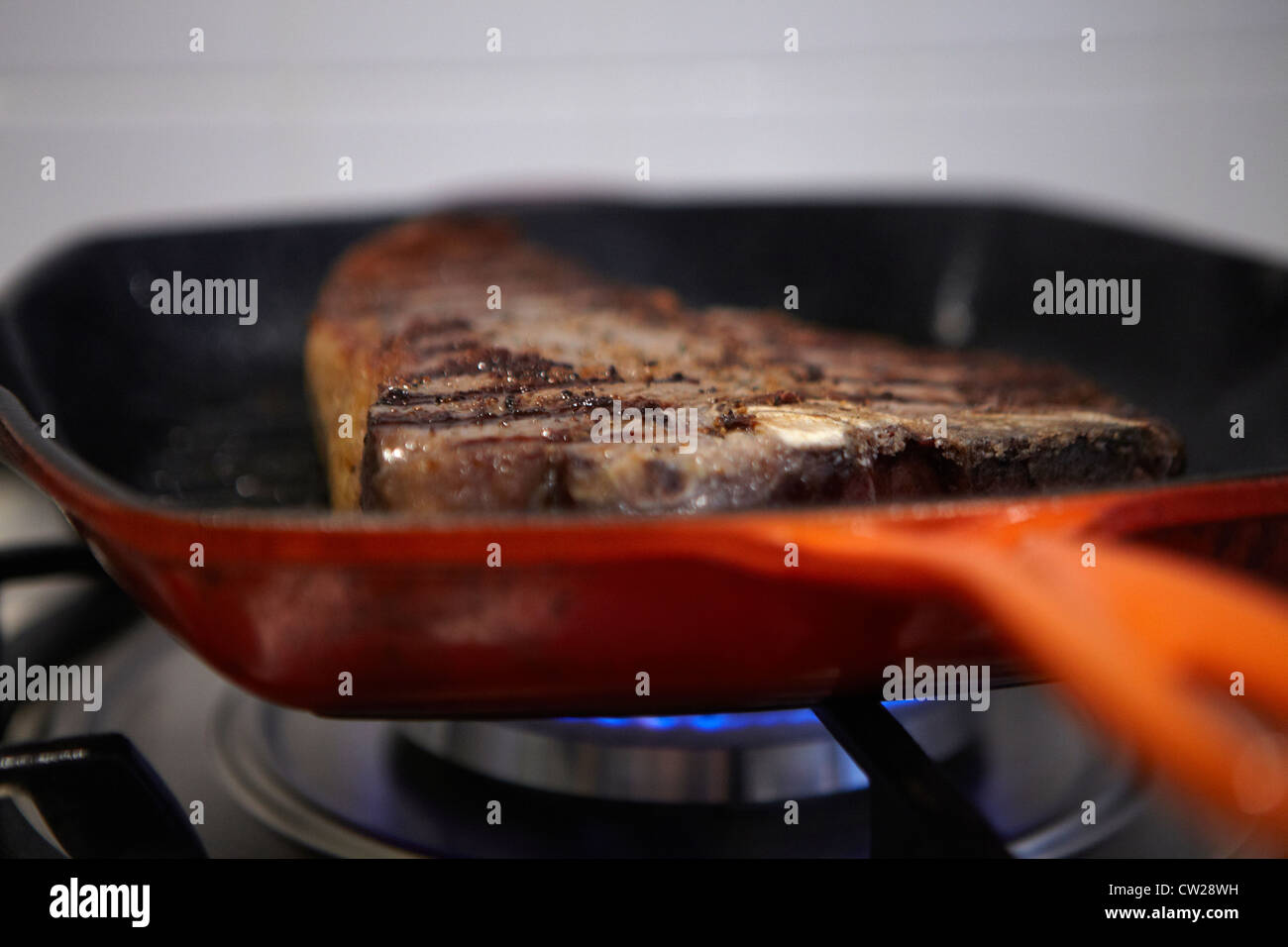 Tbone steak in frying pan getting cooked Stock Photo Alamy