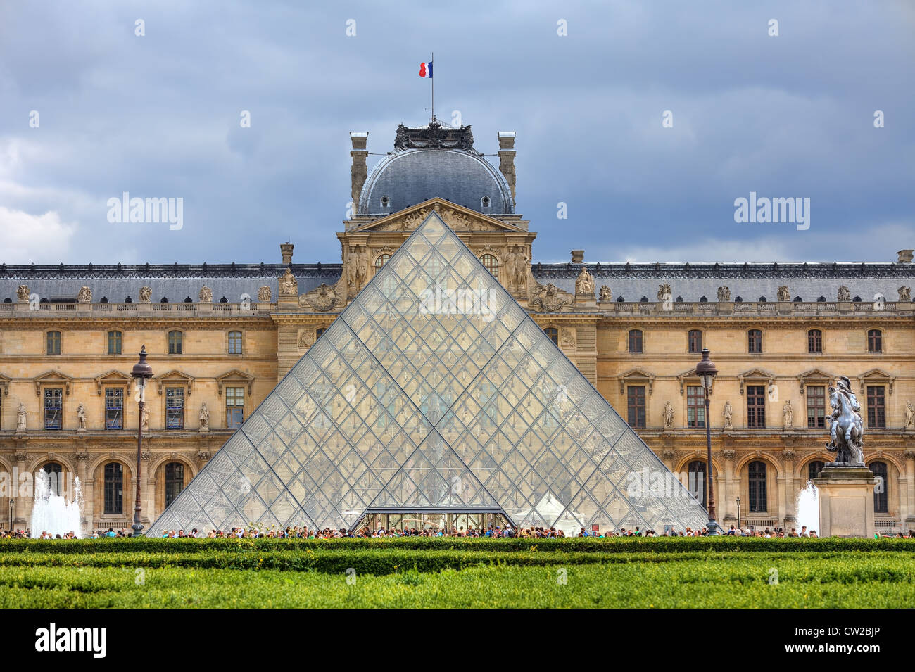 Facade of Pyramid and Louvre Museum (former Royal Palace) on background in Paris, France. Stock Photo