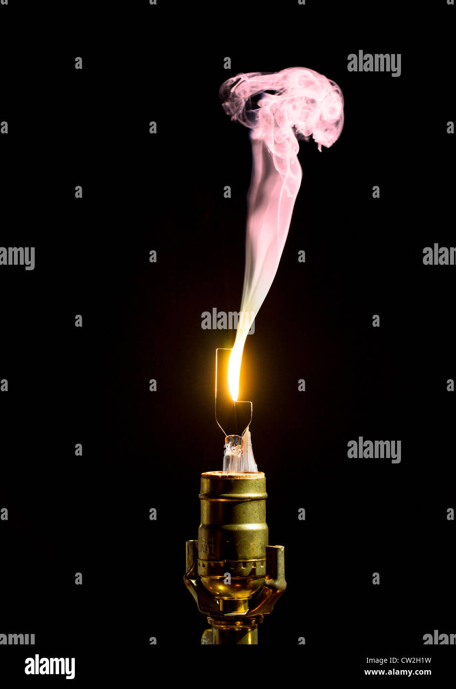 Filament on broken incandescent light bulb flares and gives off smoke