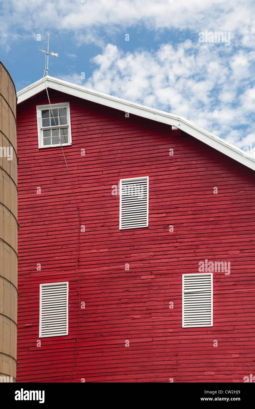 Red painted wooden barn with white door on farm in traditional American / US style Stock Photo
