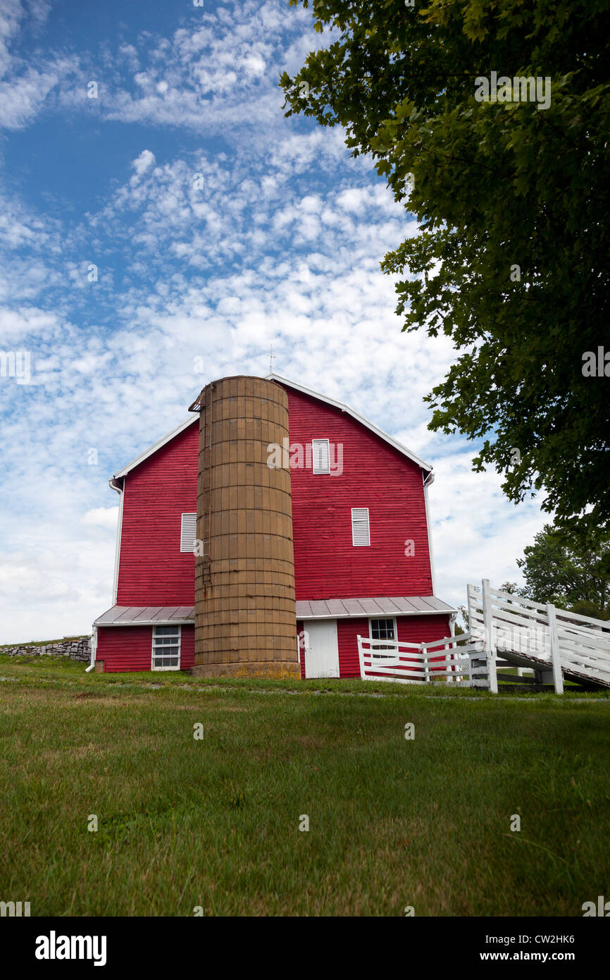 Red painted wooden barn with white door on farm in traditional US style ...