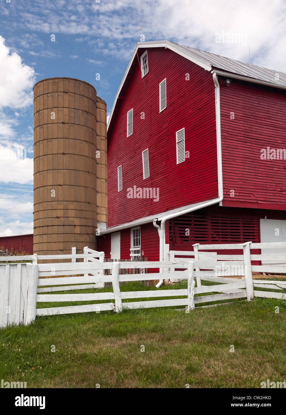 Red painted wooden barn with white door on farm in traditional US style ...