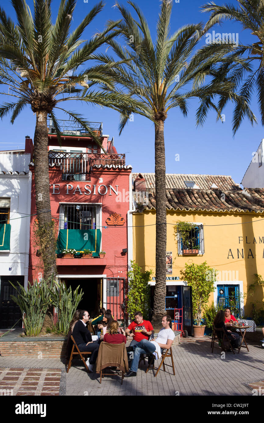 Group of friends sitting at the cafe table at Plaza Santo Cristo in Marbella, Spain. Stock Photo