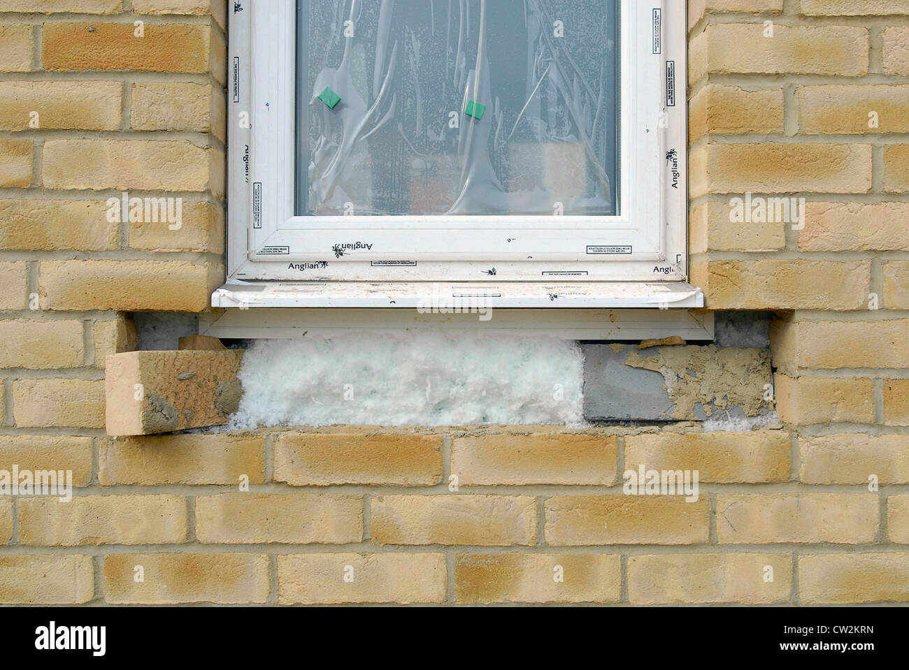 Detail of foam insulation around a PVC window during the construction