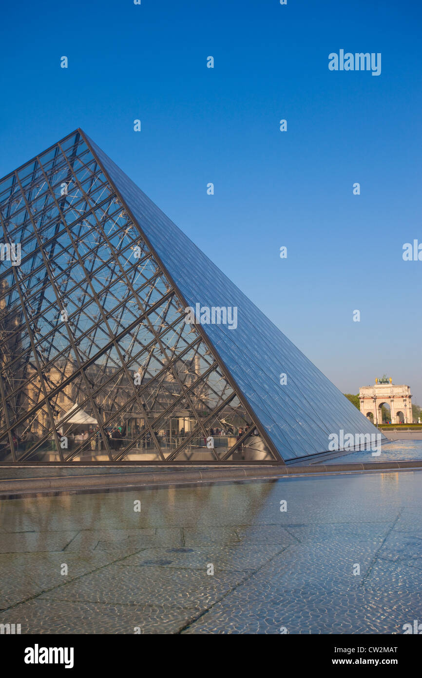 Glass pyramid at Musée du Louvre with Arc de Triomphe du Carrousel in the distance, Paris, France. Stock Photo