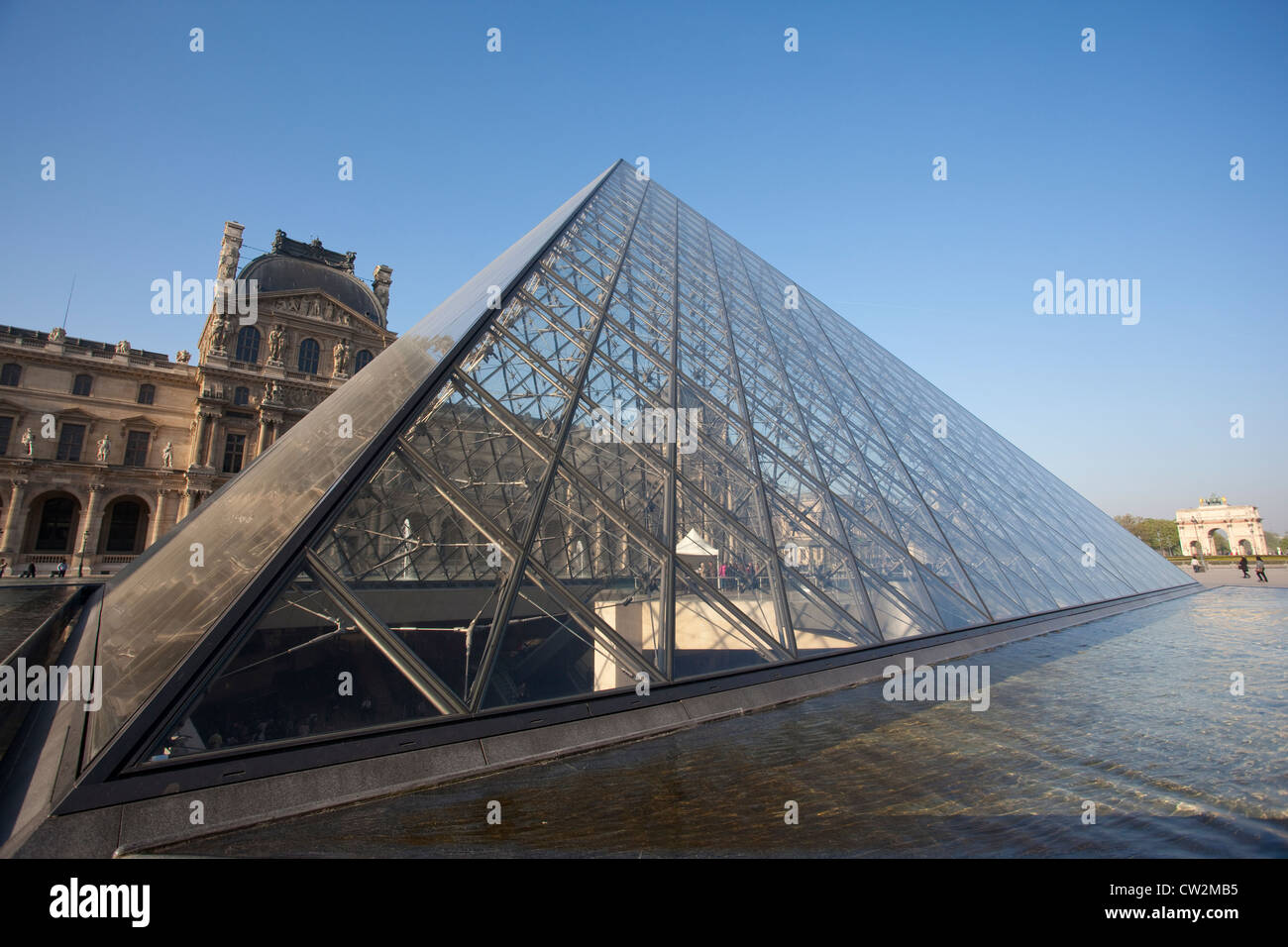 Glass pyramid at Musée du Louvre with Arc de Triomphe du Carrousel in the distance, Paris, France. Stock Photo
