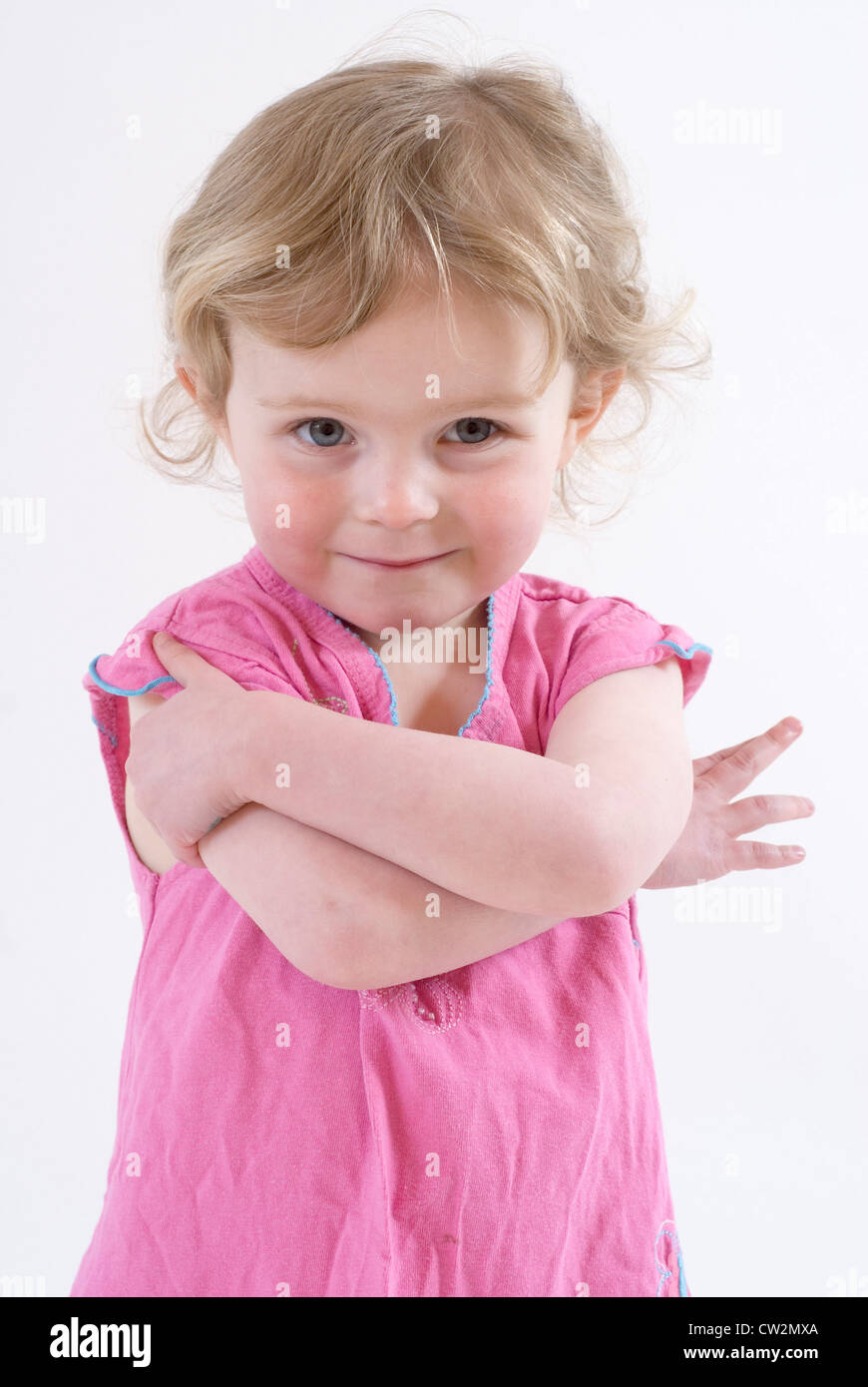 Cute Little Girl Posing with Arms Crossed in Slightly Street Gangsta Style, Studio Portrait Isolated on White Stock Photo