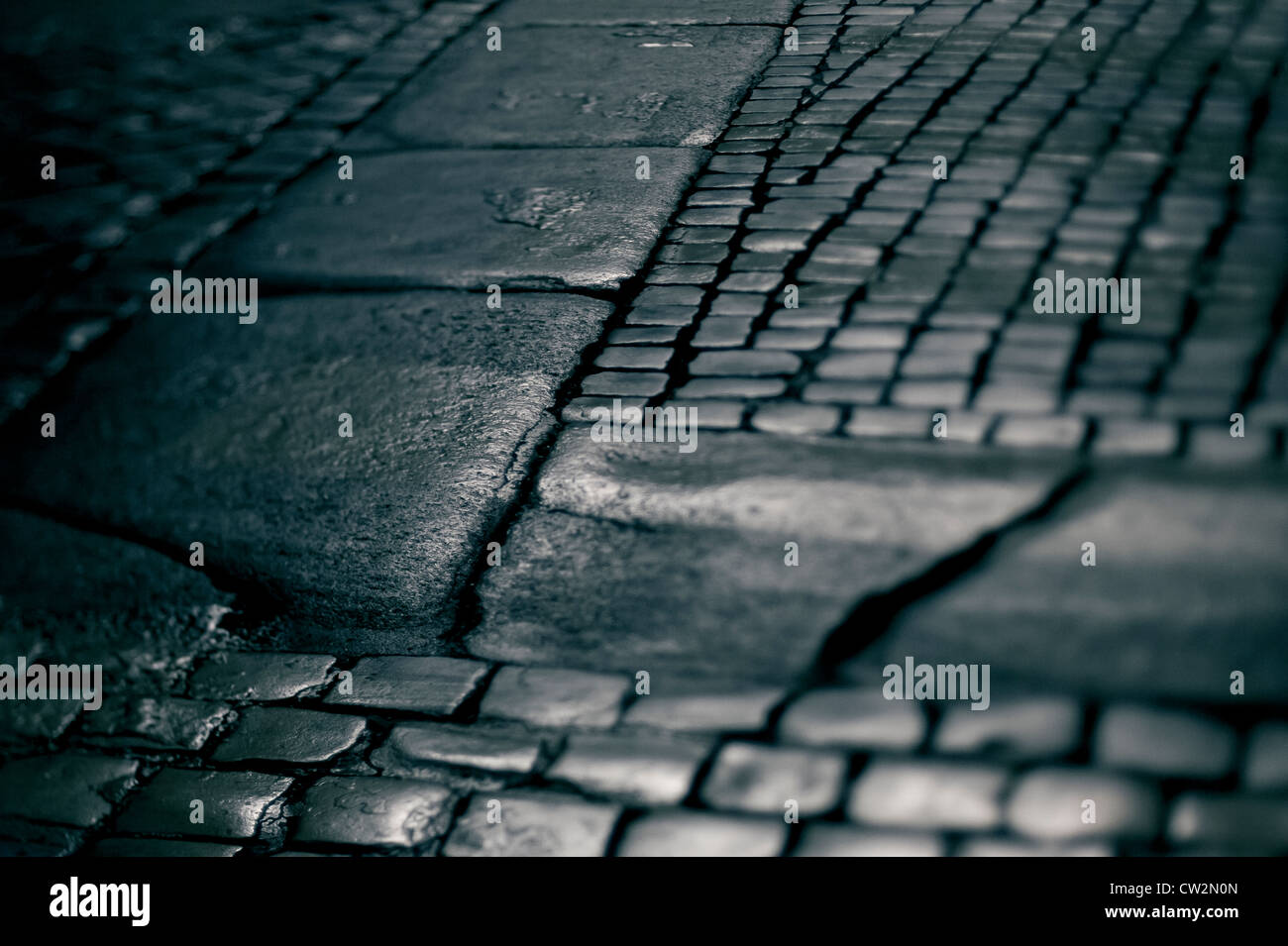 Wet cobbled street at night Stock Photo