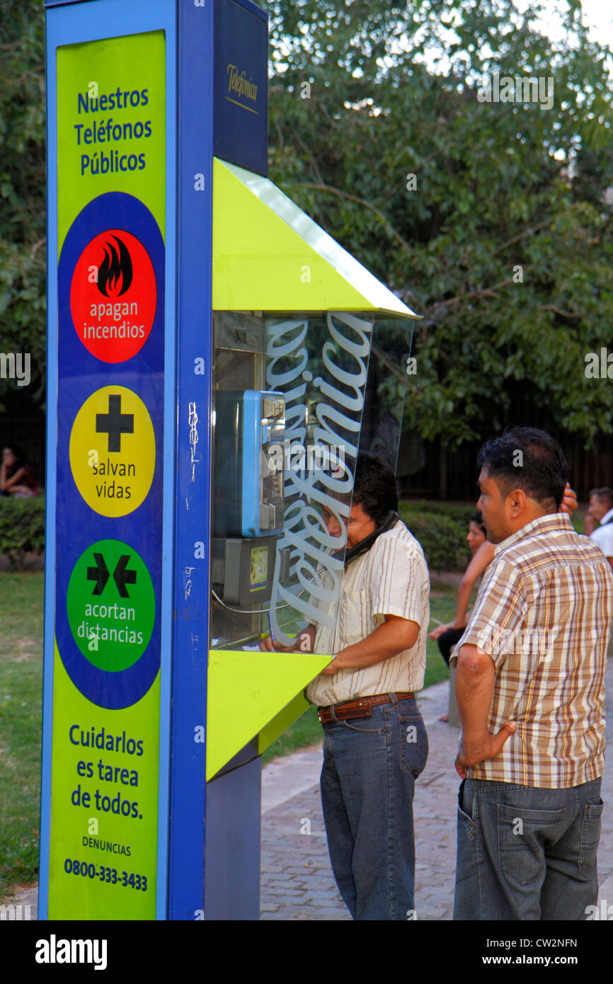 Mendoza Argentina,Avenida San Martin,public telephone booth,payphone,privacy hood,kiosk,Hispanic man men male adult adults,waiting,talking,conversatio Stock Photo