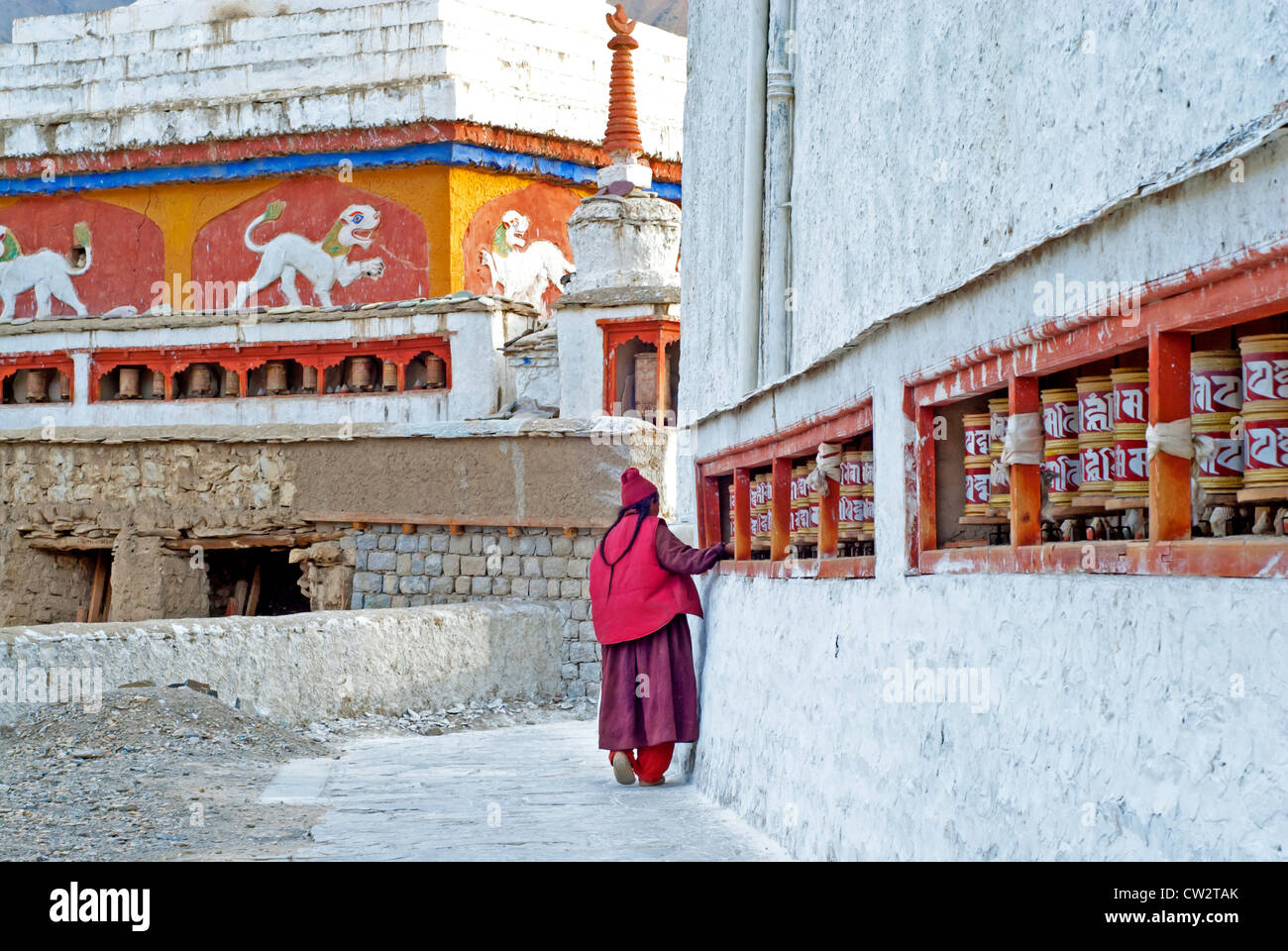 A Ladakh woman with braids spinning prayer wheels in the morning at Lamayuru Monastery in Ladakh, India Stock Photo
