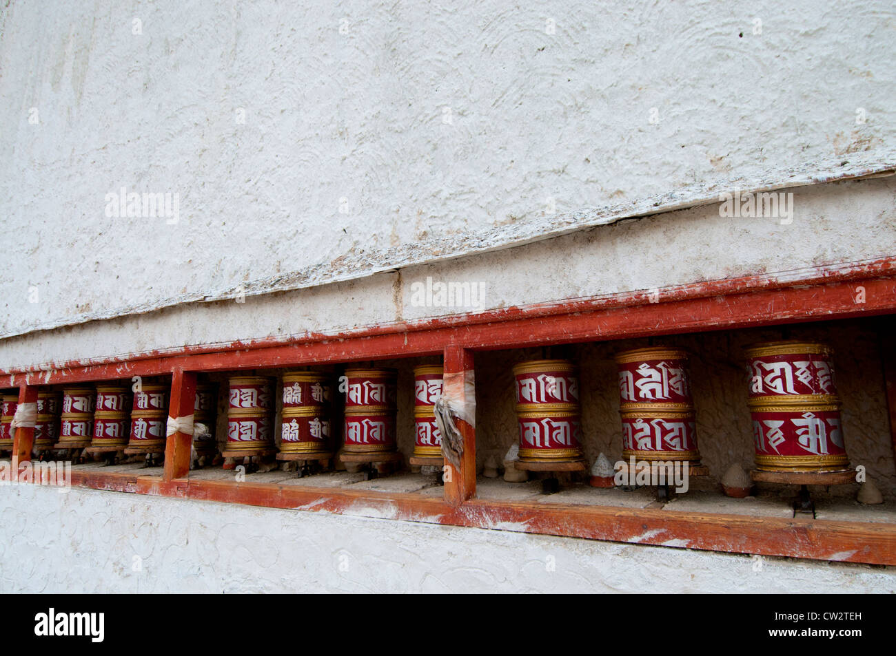 A row of prayer wheels at the Buddhist Lamayuru Monastery on the Srinagar-Kargil-Leh Road in Ladakh, India Stock Photo