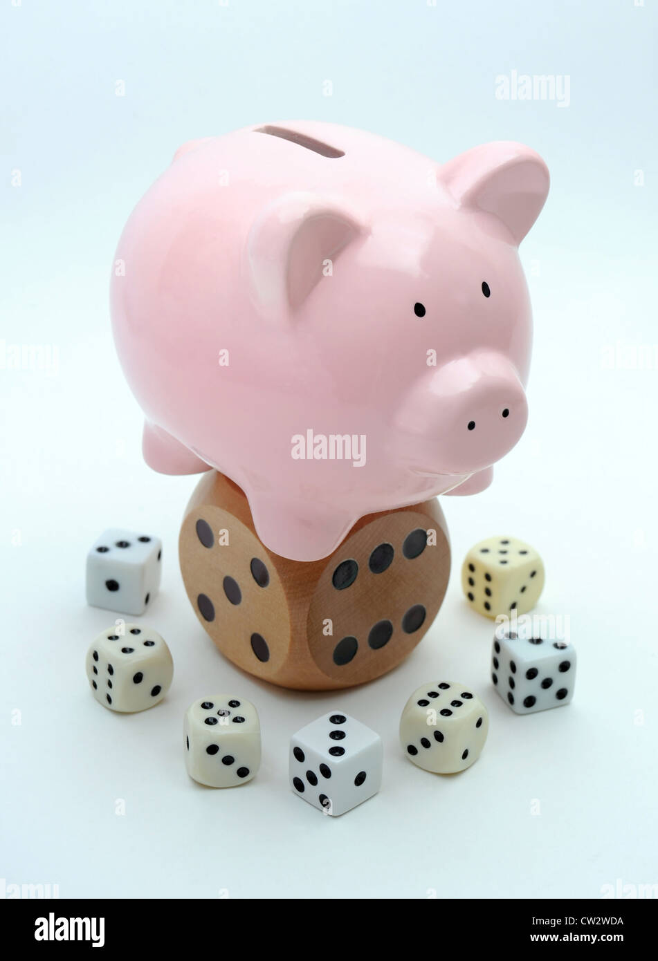 PIGGYBANK ON DICE RE WAGES GROWTH THE ECONOMY INCOMES RECESSION SALARY SALARIES HOUSEHOLD BUDGETS INFLATION SAVINGS GAMBLING UK Stock Photo