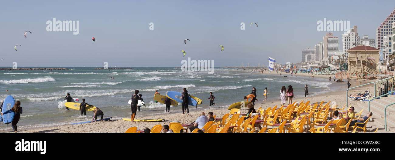 Panoramic scene of surfers entering the water along the beach in Tel Aviv, Israel Stock Photo