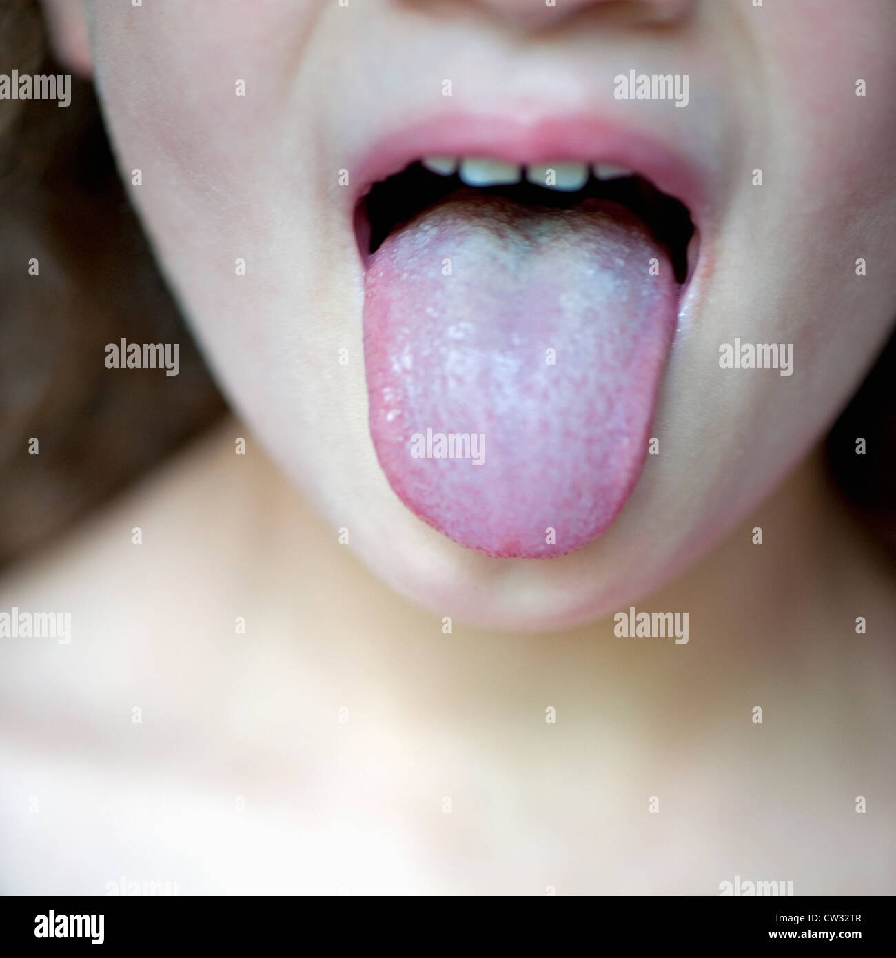 Close-up of a 4 year old girl poking out her tongue in disgust. Stock Photo