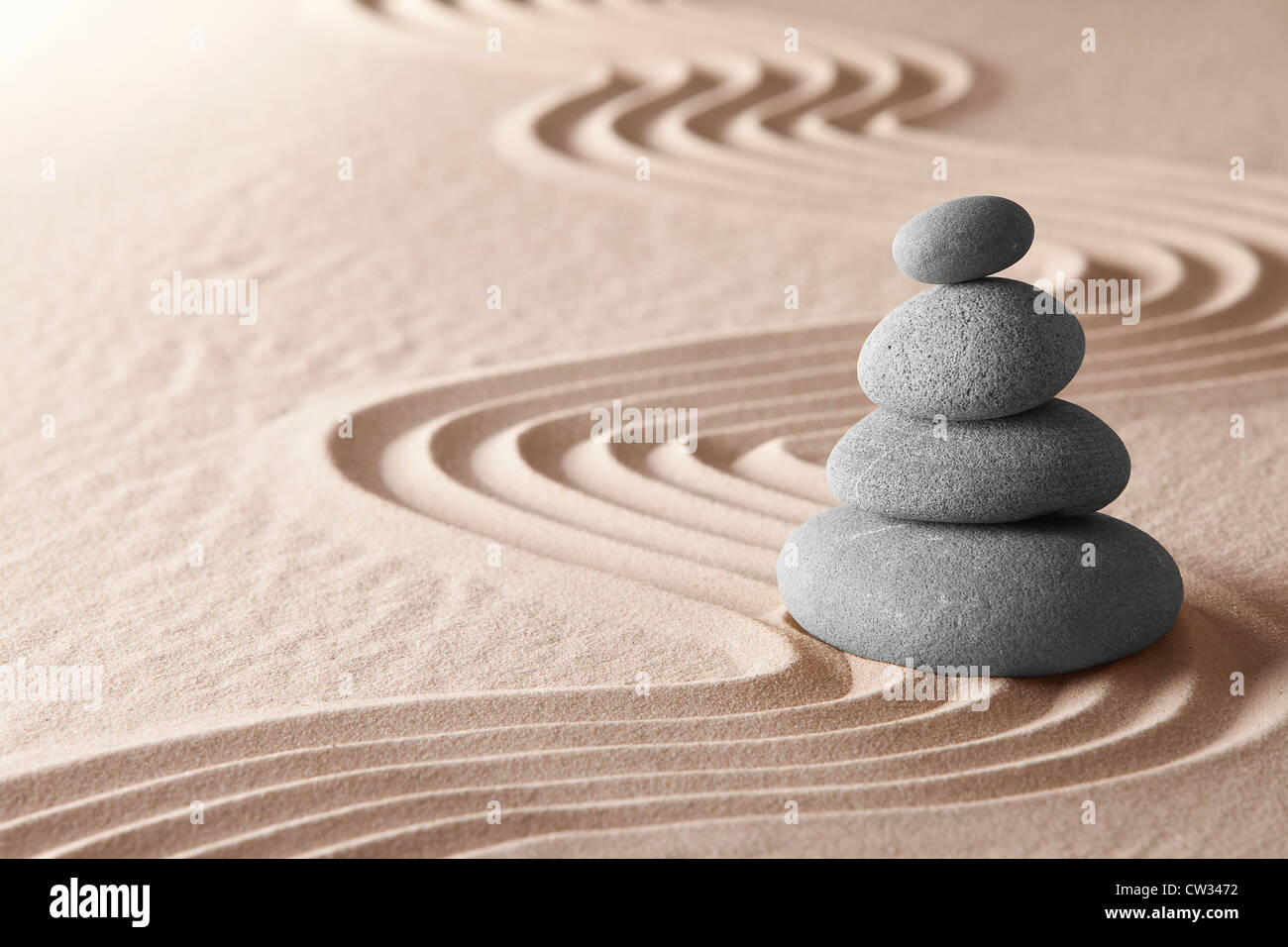 zen garden concept for balance and harmony, meditation stone and pattern of lines in sand, spiritual concentration and purity Stock Photo