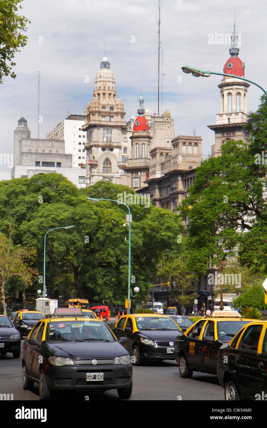 Buenos Aires Argentina,Avenida de Mayo,street scene,tree lined avenue,traffic,one way,taxi,taxis,cab,cabs,car,skyline,building,cupola,architecture bus Stock Photo