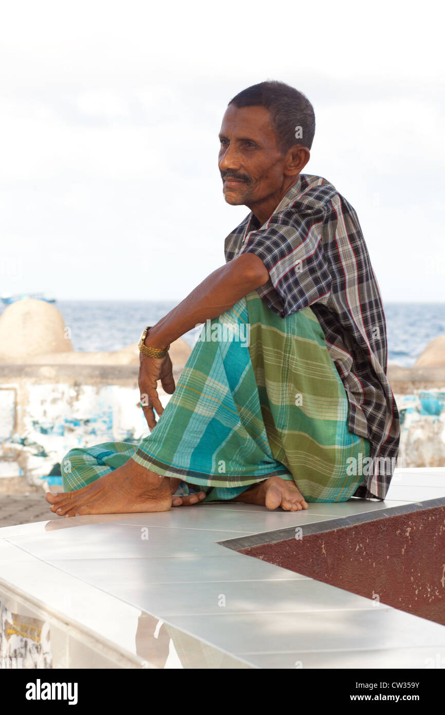 Elderly Maldivian man resting near ocean Stock Photo